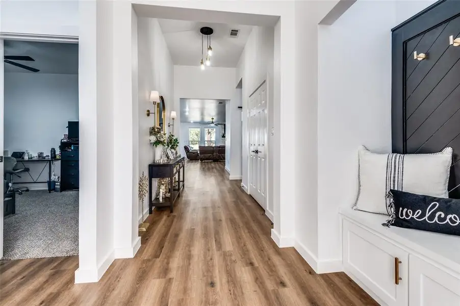 Hallway with a desk and wood finished floors