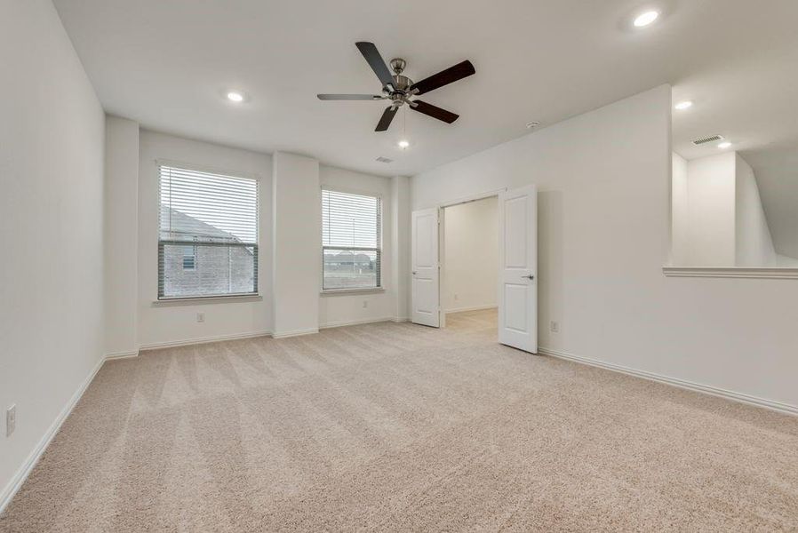 Unfurnished bedroom featuring light colored carpet and ceiling fan