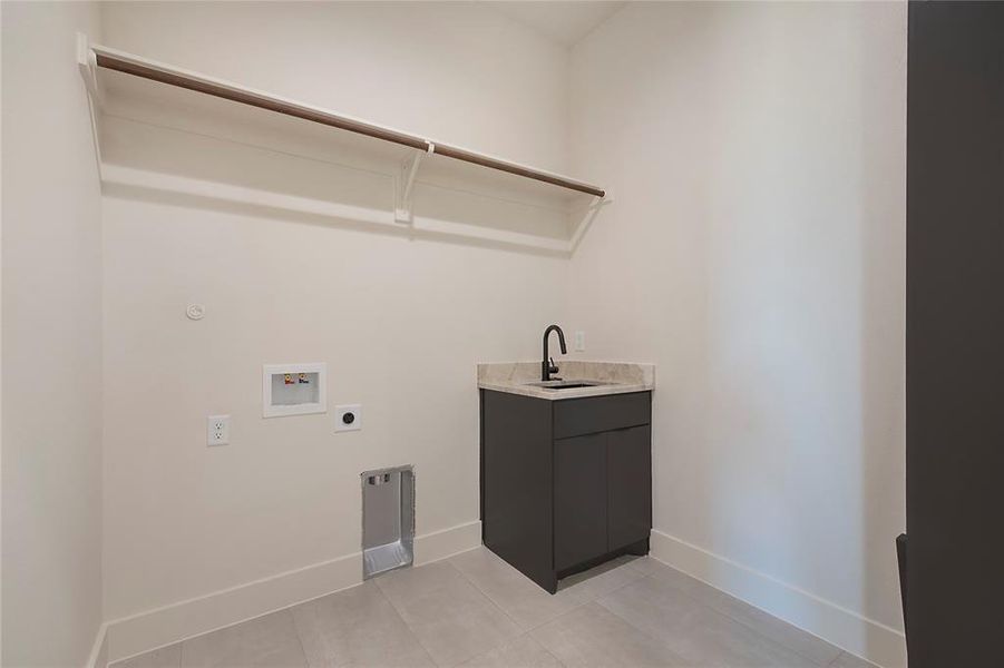Laundry area featuring hookup for a washing machine, light tile patterned flooring, and electric dryer hookup Laundry area featuring hookup for a washing machine, light tile patterned flooring, and electric dryer hookup