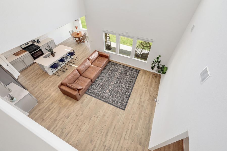 Open-concept main living area featuring high ceilings and wood-finish flooring Open-concept main living area featuring high ceilings and wood-finish flooring
