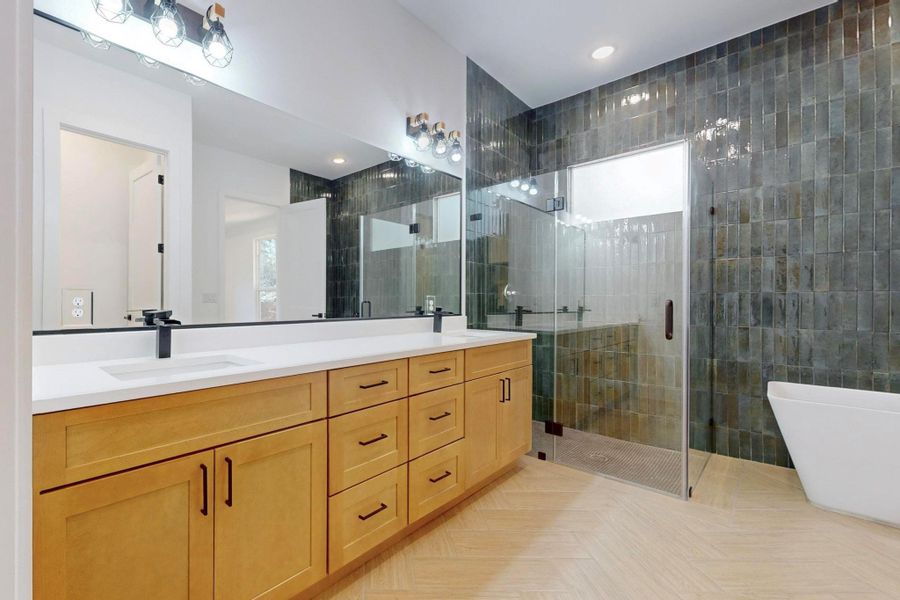 Bathroom with a shower stall, double vanity, plenty of natural light, a soaking tub, and recessed lighting