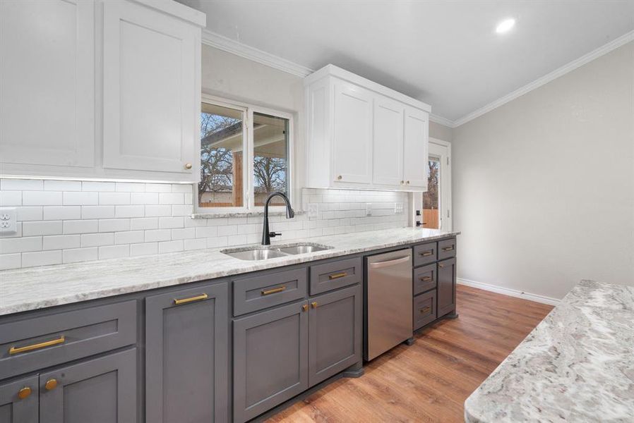 Kitchen with white cabinets, gray cabinetry, dishwasher, and sink Kitchen with white cabinets, gray cabinetry, dishwasher, and sink
