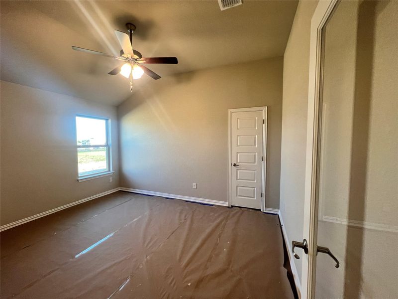 Spare room with carpet flooring, lofted ceiling, and a ceiling fan