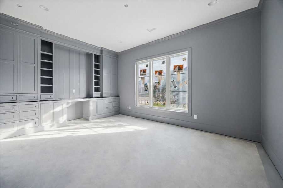 STUDY - Custom gray built ins wrap the room with extensive cabinetry, shelving, and a dedicated desk area, creating a highly functional space for work/study. Tall ceilings, soft natural light, and a cohesive color palette allow the room to adapt easily as needs change over time. -- Construction as of 1/5/26