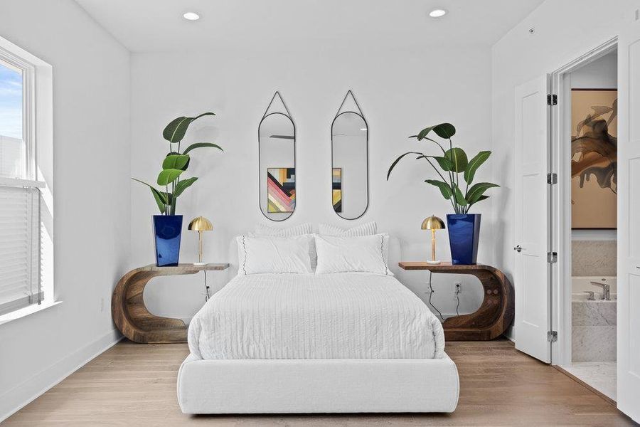 Bedroom with wood finished floors and multiple windows