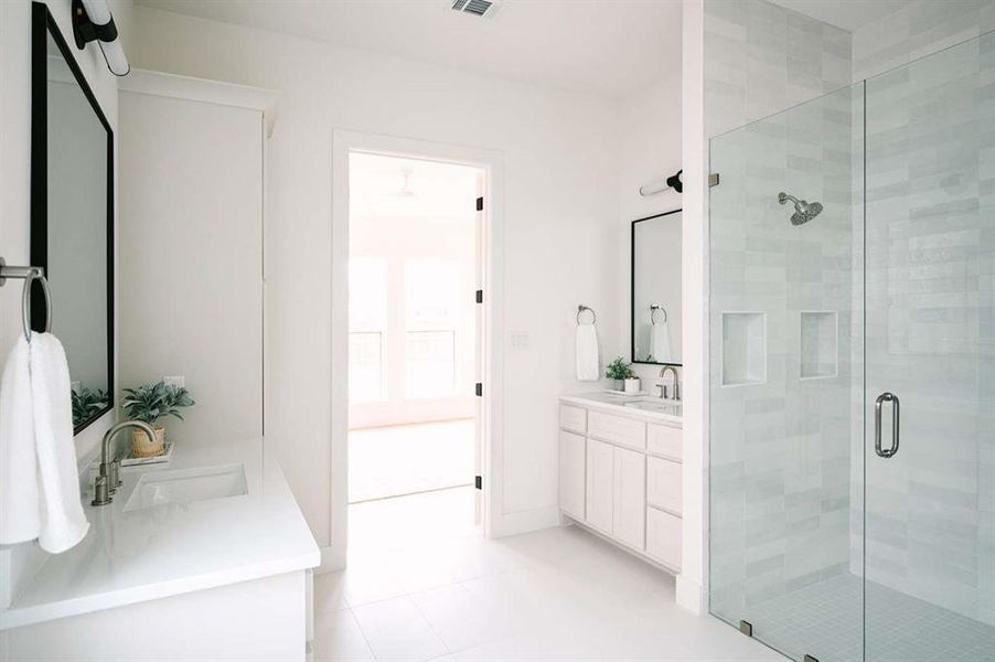 Bathroom featuring tile patterned flooring, an enclosed shower, and vanity