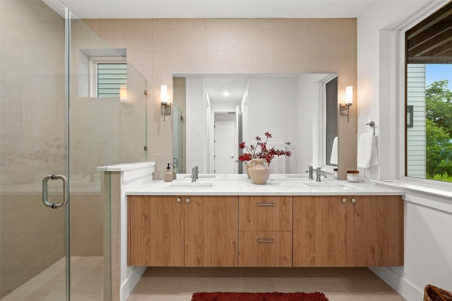 A well-lit primary bathroom features a floating double vanity and a spacious walk-in shower with sleek glass doors. A well-lit primary bathroom features a floating double vanity and a spacious walk-in shower with sleek glass doors.