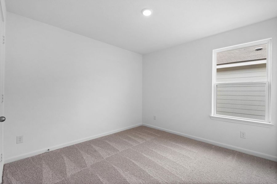 Empty room featuring carpet flooring and baseboards