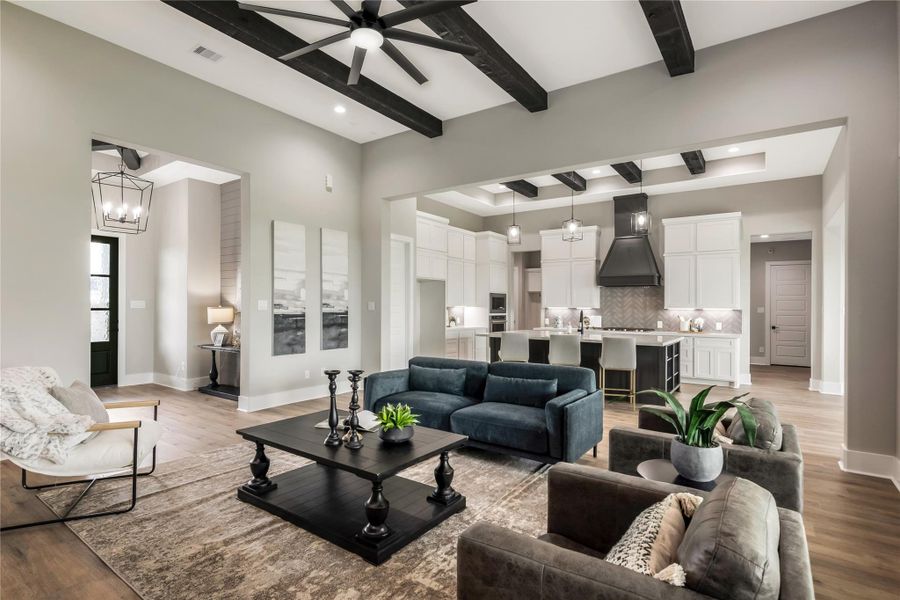 Home features elegant floors, exposed ceiling beams, and modern lighting. The spacious kitchen boasts a large island with bar seating, stylish cabinetry, and high-end appliances Home features elegant floors, exposed ceiling beams, and modern lighting. The spacious kitchen boasts a large island with bar seating, stylish cabinetry, and high-end appliances