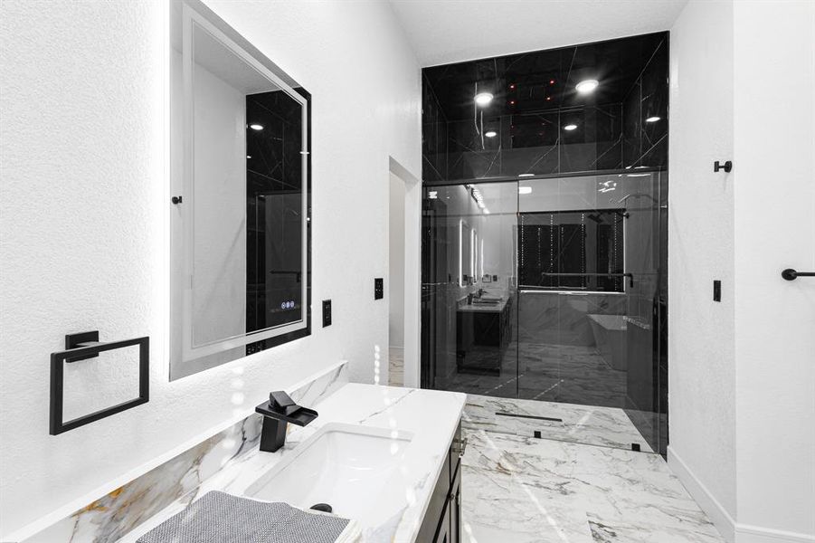 Bathroom featuring vanity, a marble finish shower, and marble finish floors