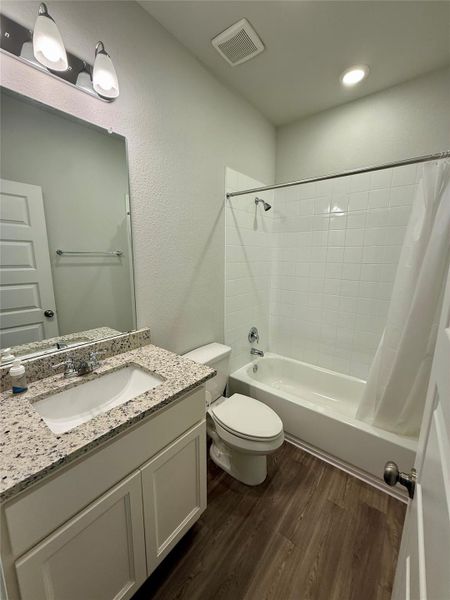 Bathroom featuring a white vanity with a speckled countertop, integrated sink, and chrome fixtures