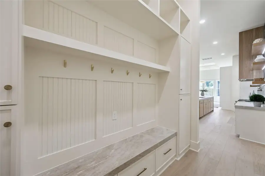 MUD ROOM: Functional mudroom offers built-in storage lockers, bench seating, hooks, and extensive cabinetry to keep everyday essentials organized.