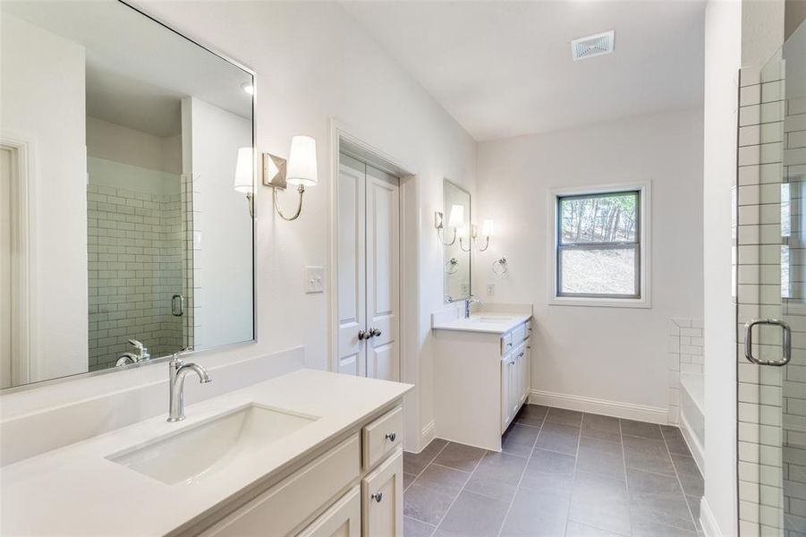 Bathroom featuring vanity, shower with separate bathtub, and tile patterned floors