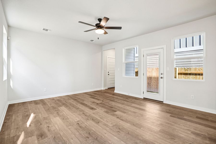 A room with a wood floor and a ceiling fan.