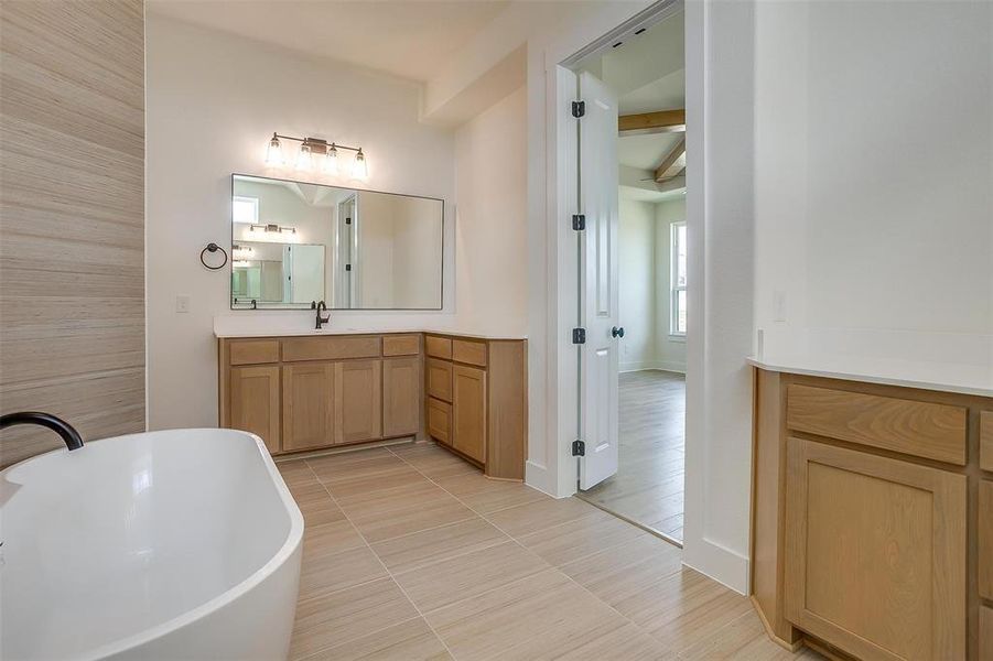 Bathroom featuring vanity, tile patterned floors, and a bathtub