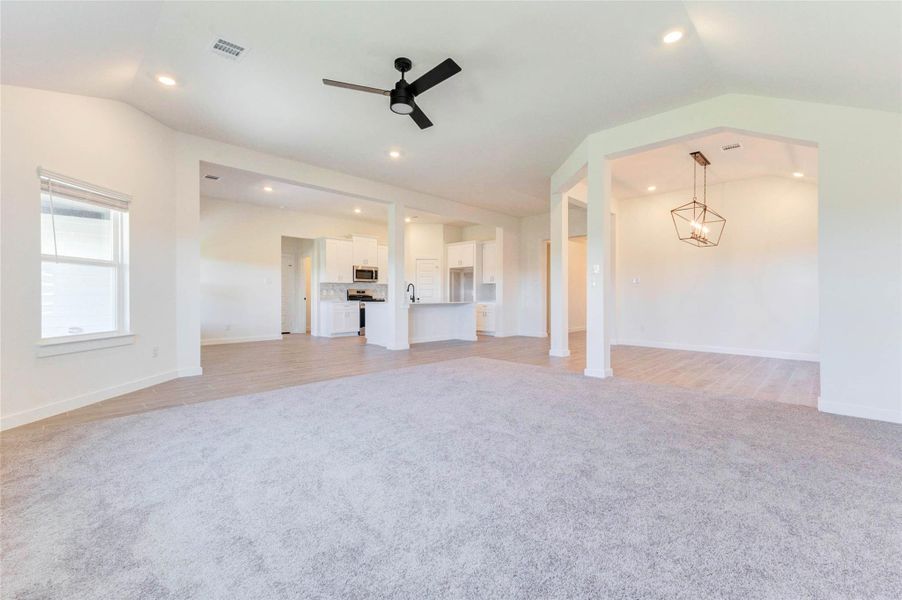 Expansive family room with open sightlines, recessed lighting, and natural light, perfect for gatherings or relaxing.