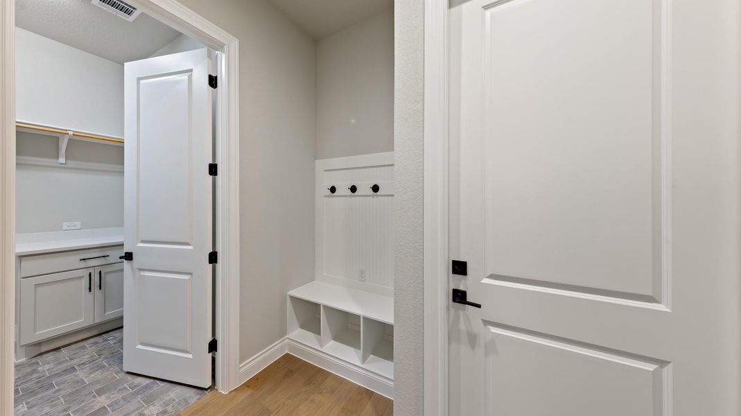 Mudroom featuring light wood-style flooring and baseboards