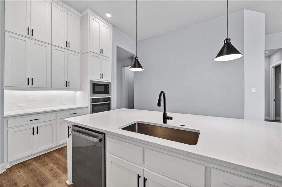 Spacious kitchen featuring an expansive island with an undermount sink and a matte black faucet Spacious kitchen featuring an expansive island with an undermount sink and a matte black faucet