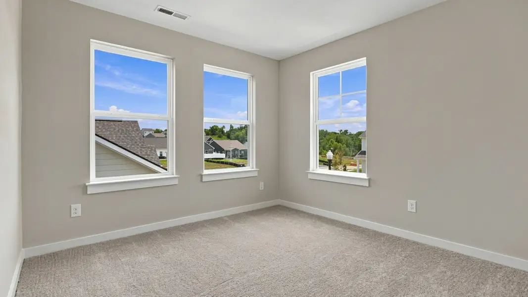 Upstairs secondary room with three windows showcasing community view Upstairs secondary room with three windows showcasing community view