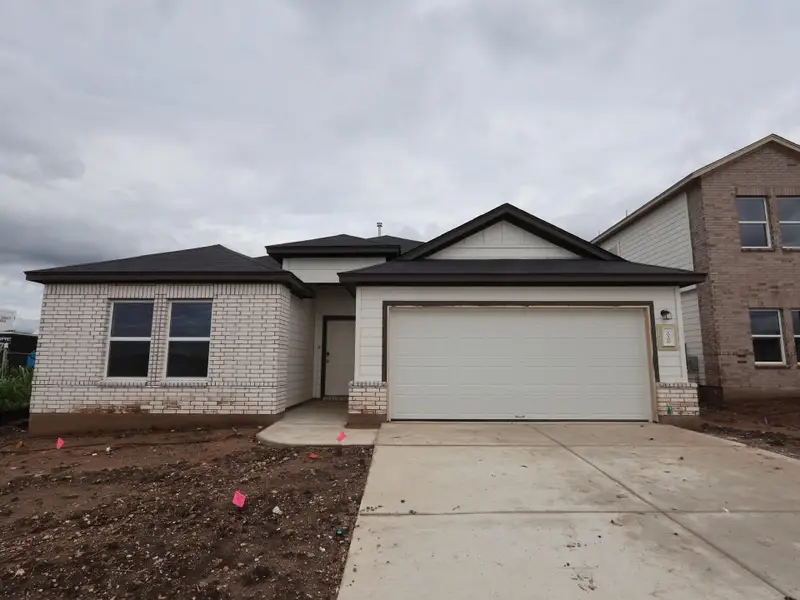 Front exterior of a new home in Willow Springs, Buda, TX, highlighting curb appeal (Image 2). Front exterior of a new home in Willow Springs, Buda, TX, highlighting curb appeal (Image 2).