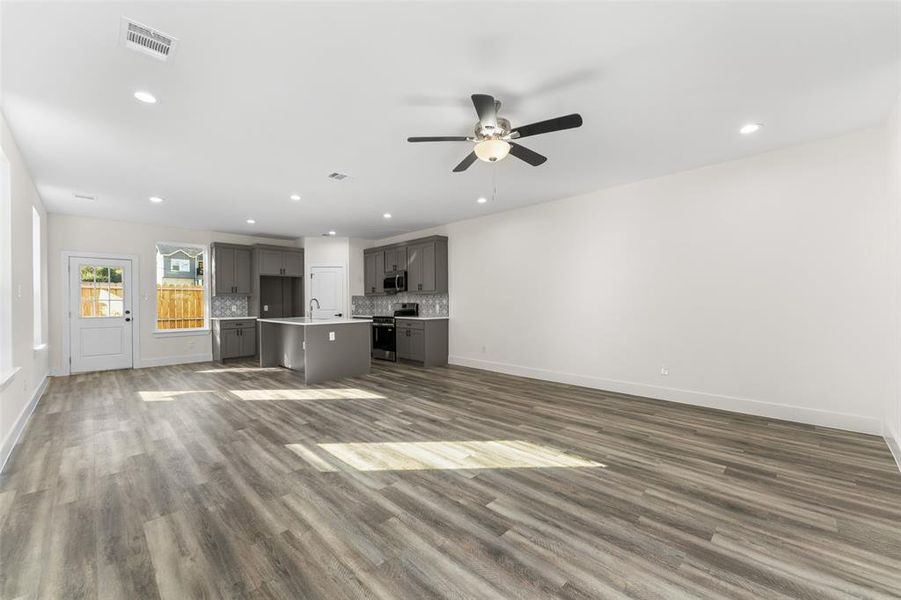 Unfurnished living room featuring recessed lighting, dark wood-style floors, and a ceiling fan Unfurnished living room featuring recessed lighting, dark wood-style floors, and a ceiling fan