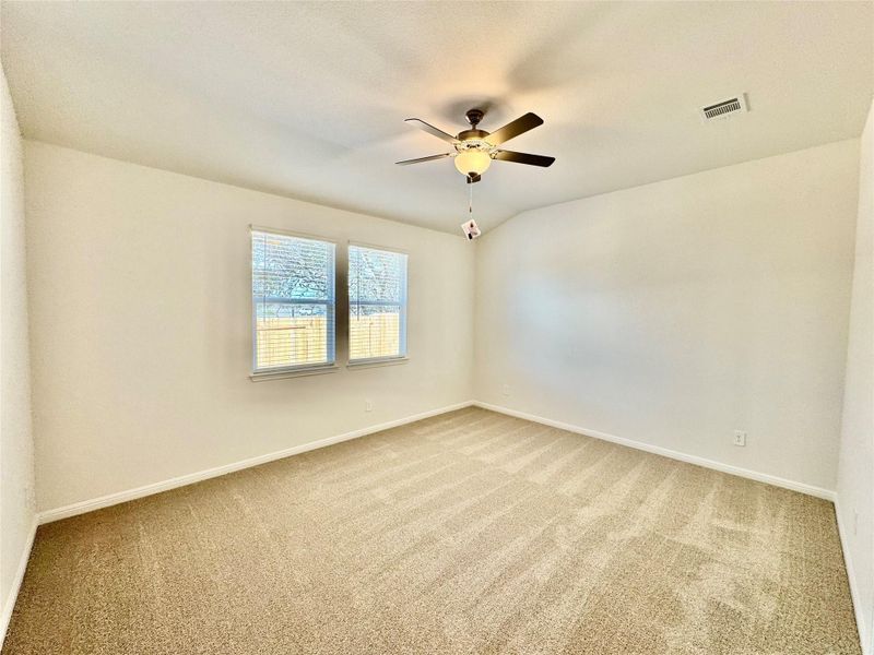 Unfurnished room with light colored carpet, a ceiling fan, and vaulted ceiling