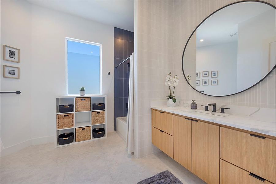 Bathroom featuring vanity, shower / bath combo with shower curtain, tile patterned flooring, and tile walls