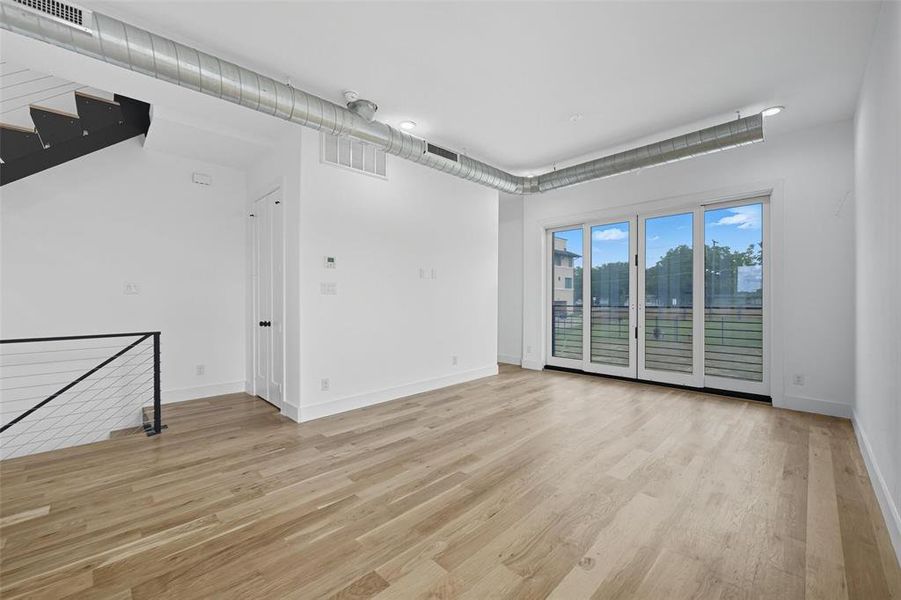 Spare room with light wood-style flooring and stairway Spare room with light wood-style flooring and stairway