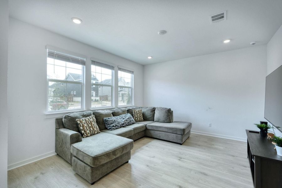 Living room featuring baseboards, recessed lighting, visible vents, and light wood-style floors