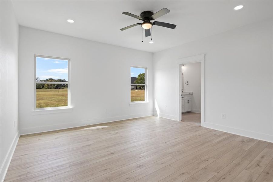 Unfurnished bedroom with a ceiling fan, recessed lighting, light wood-style flooring, and connected bathroom