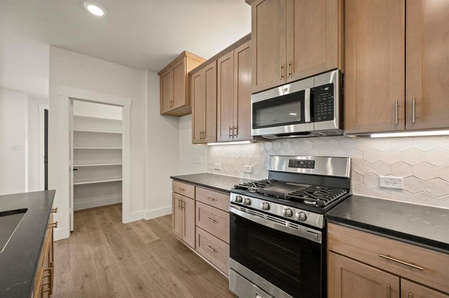 Thoughtful design elements like pot & pan drawers, pull out trash drawer and walk in pantry can be found in this dream kitchen!