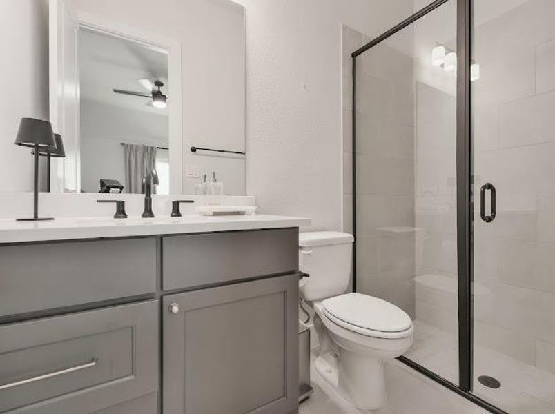 Full bath featuring vanity, a shower stall, and a ceiling fan Full bath featuring vanity, a shower stall, and a ceiling fan