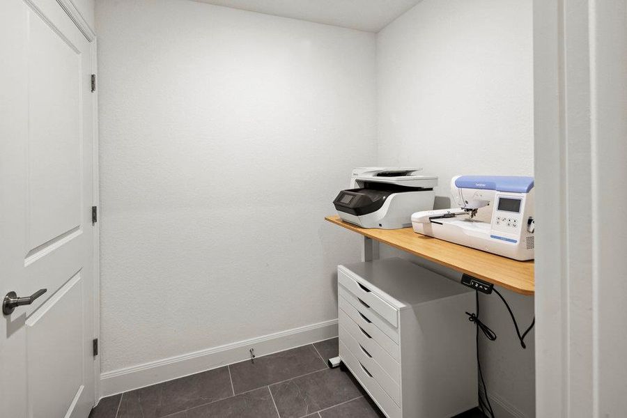 Office area with baseboards and dark tile patterned flooring