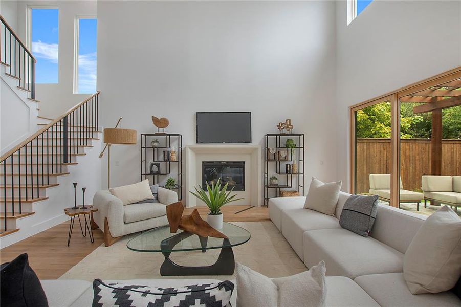 Living room featuring a high ceiling and light hardwood / wood-style floors