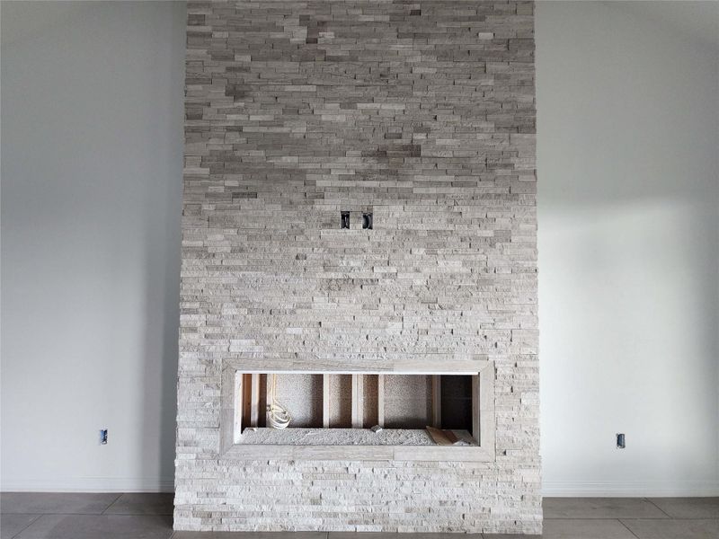 Floor-to-ceiling split-face stone accent wall featuring a rectangular hearth opening
