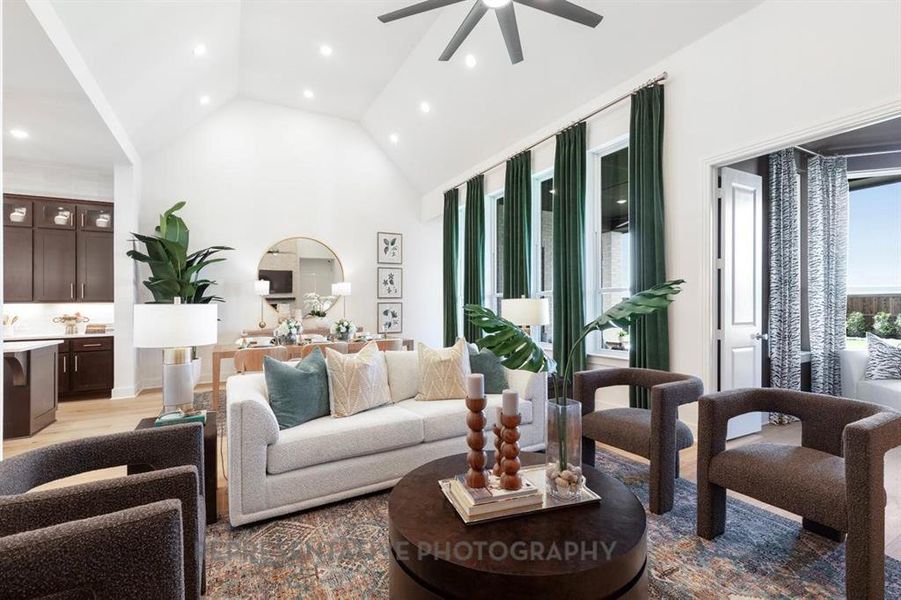 Living room featuring light wood-style floors, high vaulted ceiling, recessed lighting, and ceiling fan