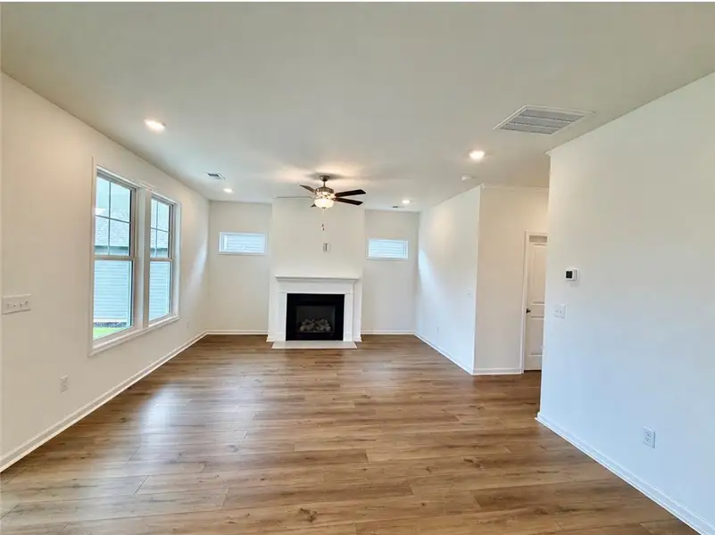 Rich wood-inspired floors and a classic fireplace