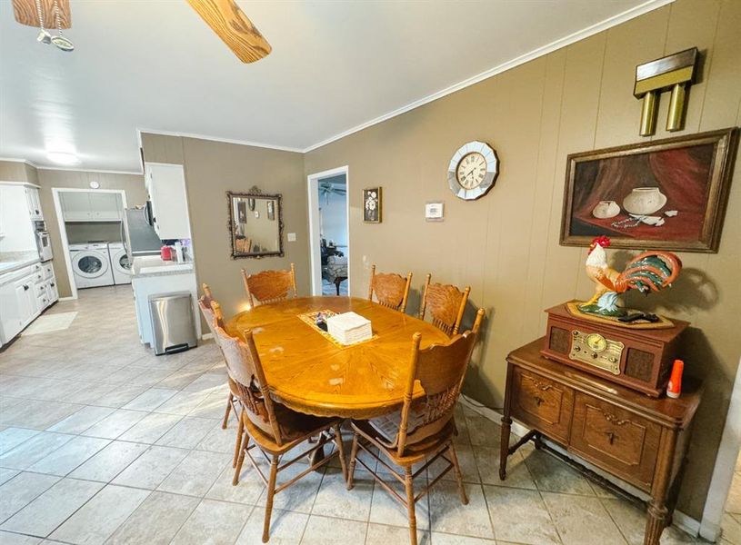 Dining area featuring crown molding, light tile patterned floors, and ceiling fan
