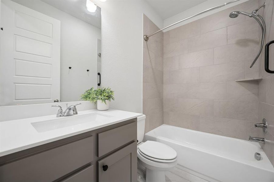 Bathroom featuring a built-in tub and shower combination with light-toned rectangular tile surround, a built-in shower shelf, and a curved shower rod