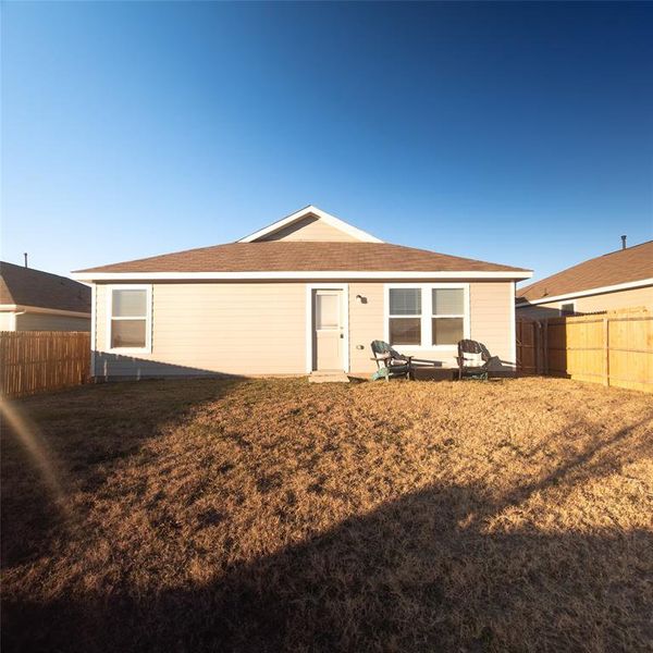 Rear view of house featuring a yard