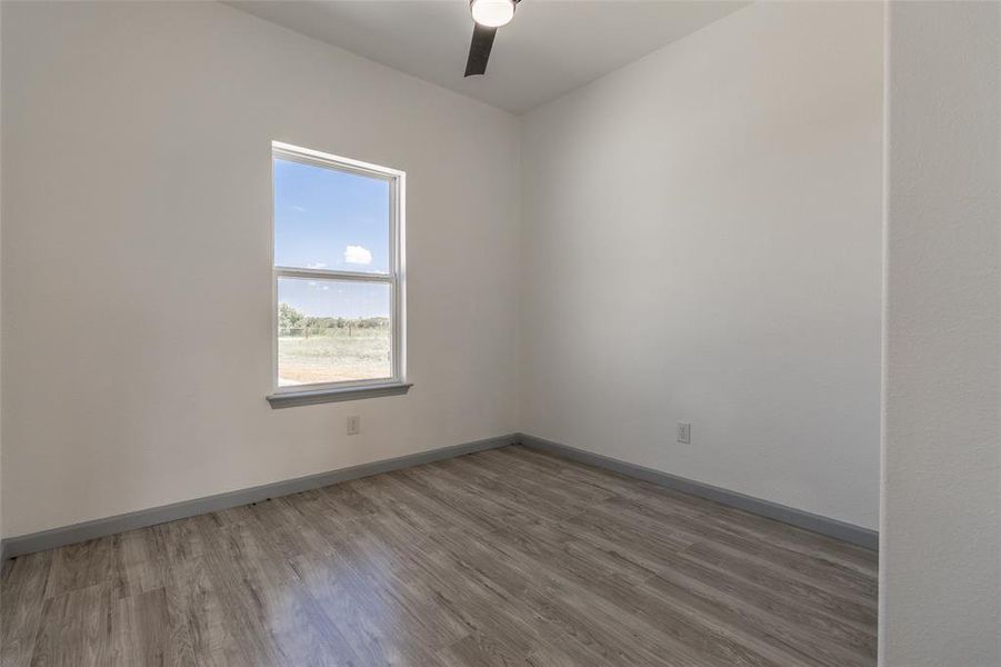 Empty room with light hardwood / wood-style flooring and ceiling fan