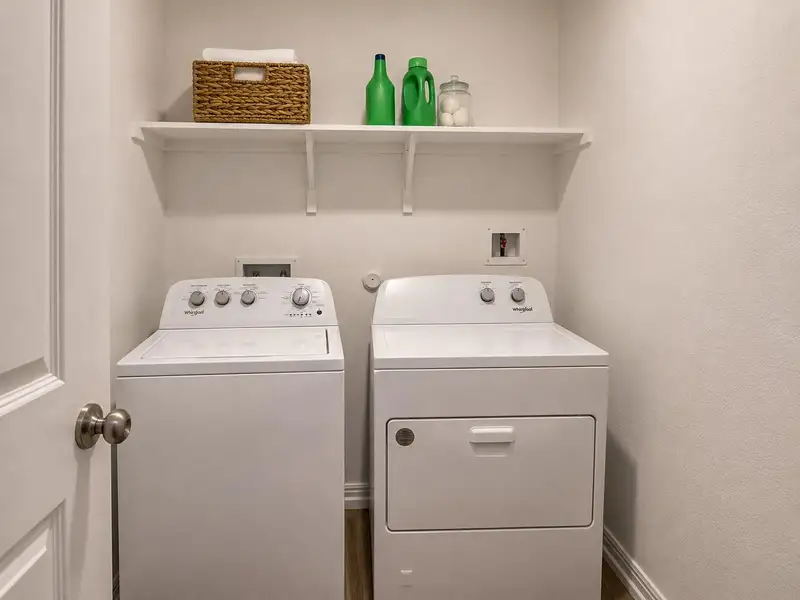 A well-appointed laundry area features a practical shelf and modern appliances for daily convenience. A well-appointed laundry area features a practical shelf and modern appliances for daily convenience.