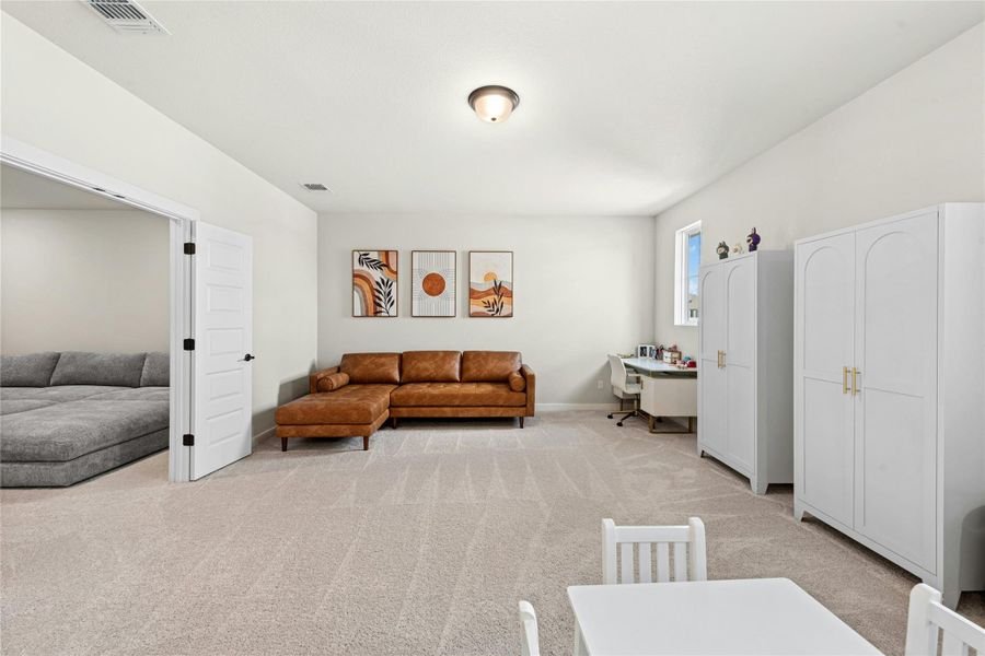 Living room with light carpet and an office area