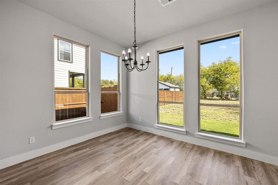 Unfurnished dining area featuring light wood-style floors and a chandelier