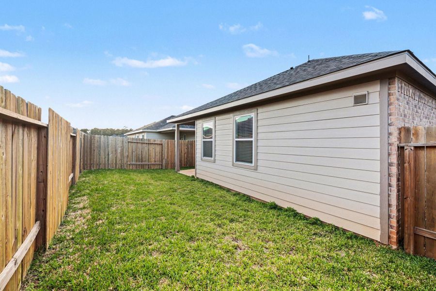 Spacious backyard with wood fencing and room for play or pets. Spacious backyard with wood fencing and room for play or pets.