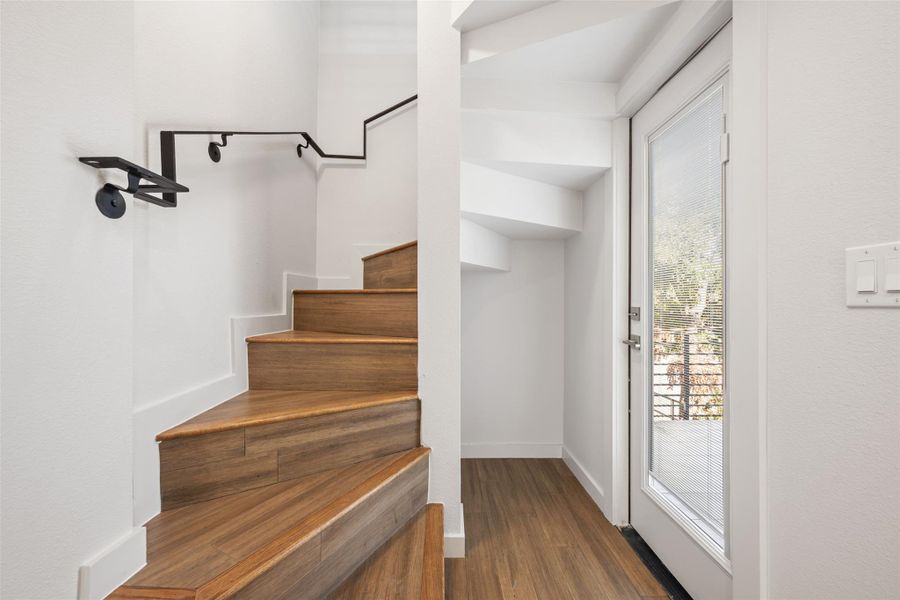 Stairway with wood finished floors and baseboards