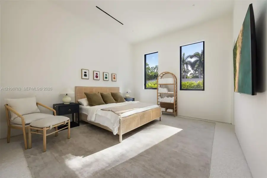 High-ceilinged room featuring recessed linear lighting, polished concrete flooring, and dual vertical windows