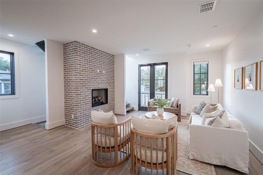 Living room with a fireplace and light wood-type flooring