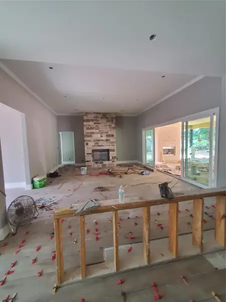 LIVING ROOM WITH STONE FIREPLACE WITH PREMIUM TILE WOOD PLANKS BEING INSTALLED