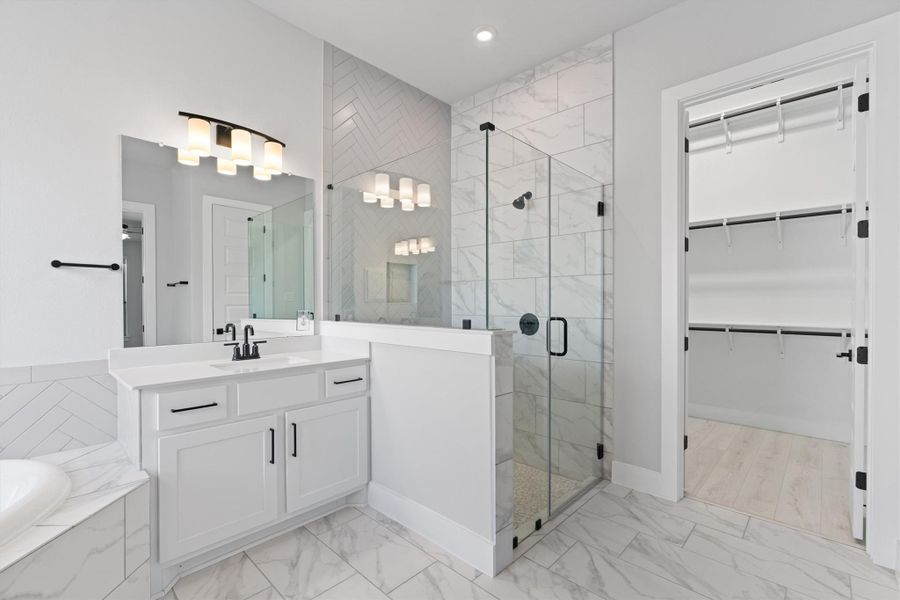 Full bathroom featuring a shower stall, vanity, a garden tub, a spacious closet, and recessed lighting